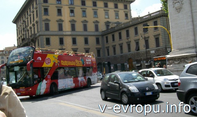 Рим. Обзорные экскурсии на автобусе. Красный экскурсионный автобус Сити Сайтсиинг Рома поворачивает на мост Витторио Эмануэле